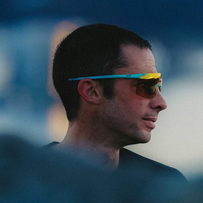 Man wearing colorful sunglasses with a blurred background