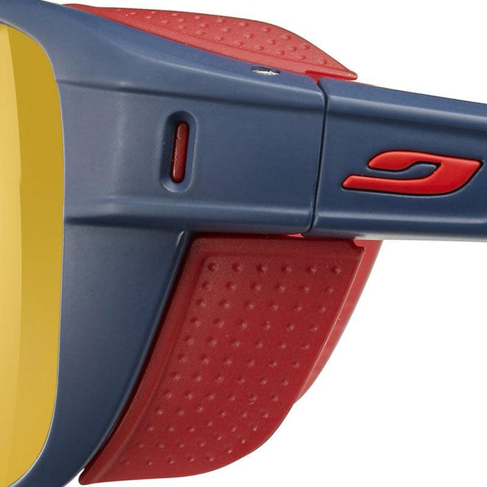 Close-up of the side of Julbo USA Camino Lenses & Parts: blue and red sunglasses with yellow lenses, textured red temples, and protective side shields.