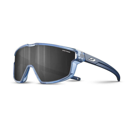 The Julbo-usa Fury Mini Kids sunglasses feature a translucent blue frame, large dark wraparound lenses with SPECTRON printed on them, and a logo on the temple—perfect for kids on the pump track. #color_translucent-blue-matte-blue-with-spectron-3-lens