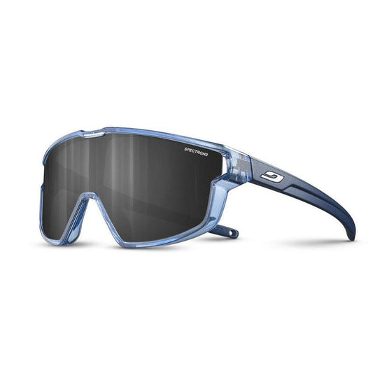 The Julbo-usa Fury Mini Kids sunglasses feature a translucent blue frame, large dark wraparound lenses with SPECTRON printed on them, and a logo on the temple—perfect for kids on the pump track. #color_translucent-blue-matte-blue-with-spectron-3-lens