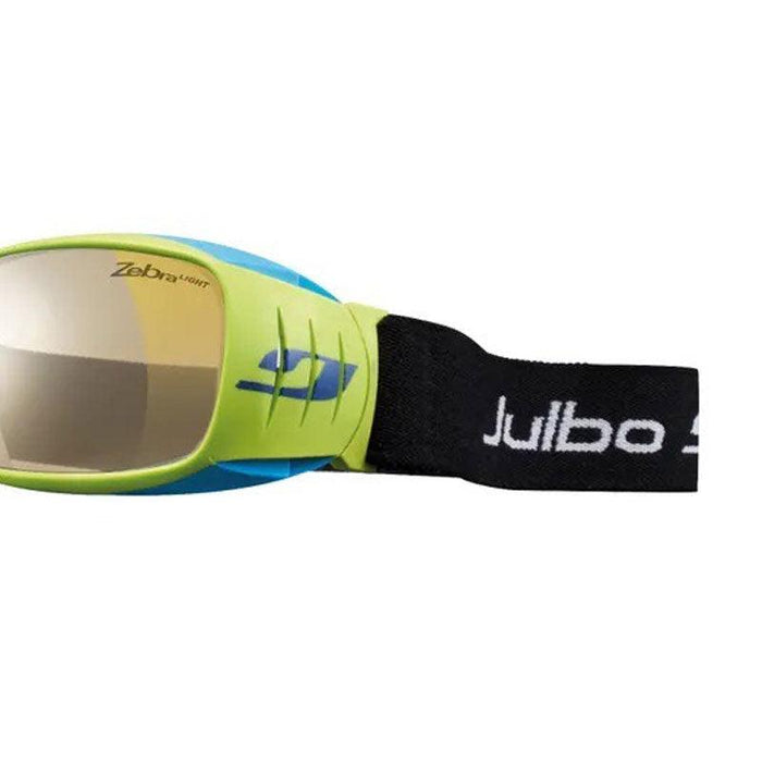 Close-up of Julbo Eyewear goggles with a yellow frame, mirrored lens, blue side vent, and a black Tensing Flight Strap featuring the white Julbo logo.