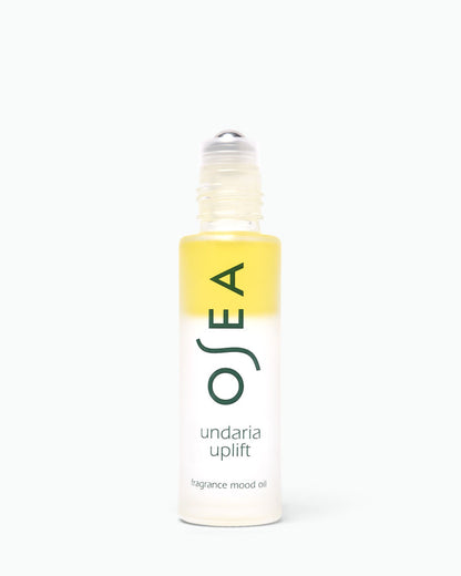 A bottle of OSEA Undaria Uplift fragrance mood oil with a yellow-to-clear gradient label and a clear rollerball cap, centered on a white background.