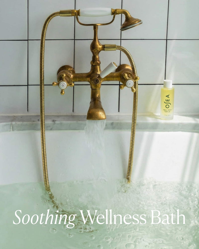 Gold bathtub faucet with running water, OLEA bottle, and 'Soothing Wellness Bath' text.