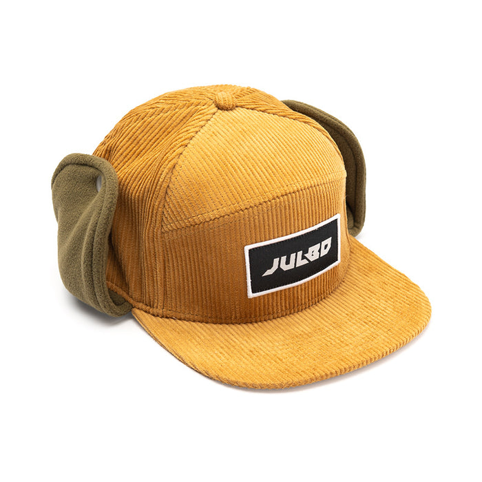 The Julbo Eyewear Woodsman Hat is a mustard yellow corduroy earflap hat with a black-and-white rectangular logo patch—ideal for cold weather adventures. #color_julbo-woodsman-hat-tan
